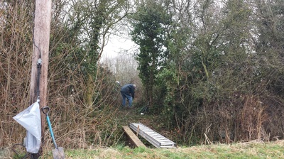 A volunteer clearing the forest school site.