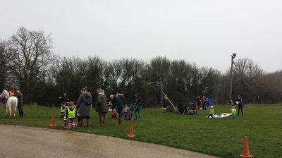 Parents and children on the village green on a winter's day.